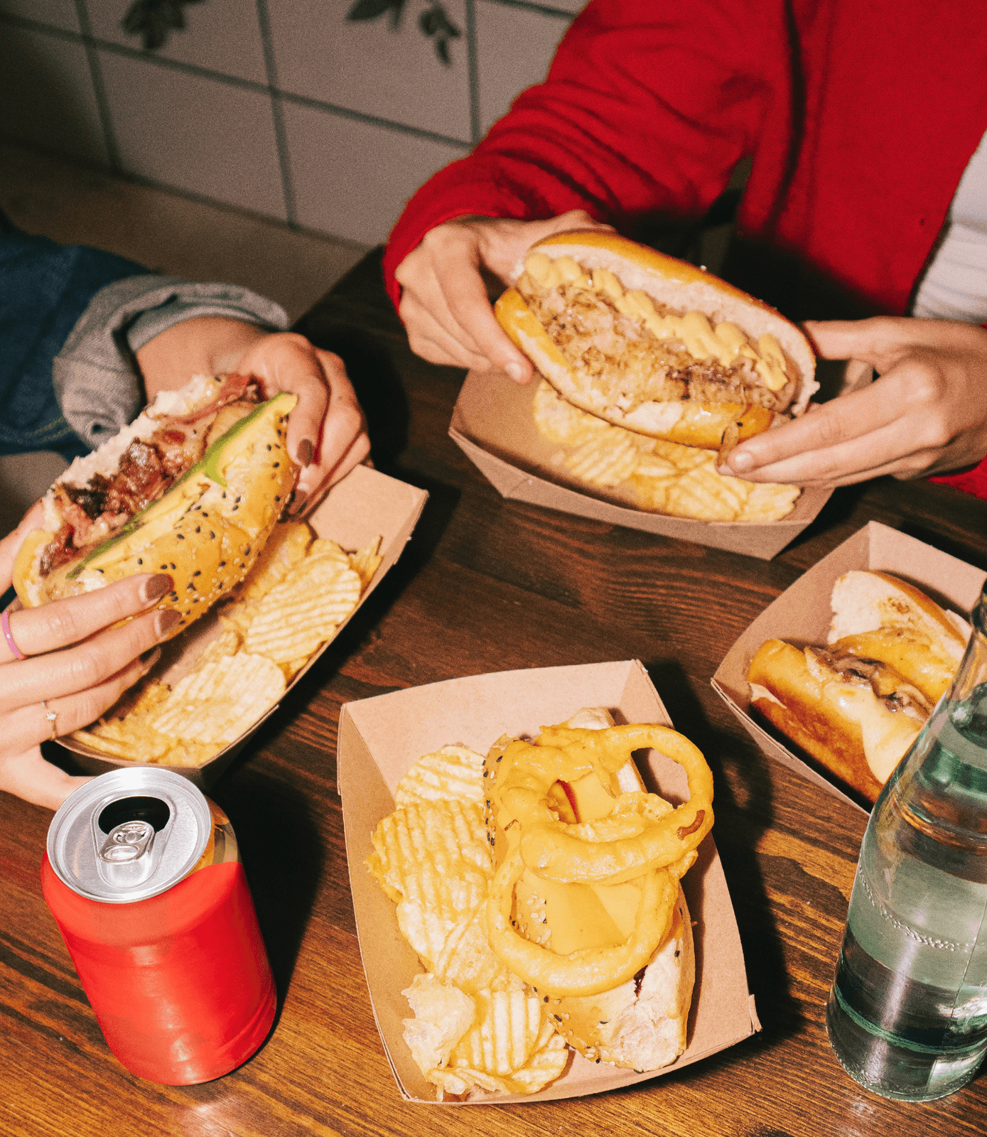 Friends sharing sandwiches and fries